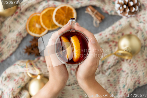 Image of hands with glass of hot mulled wine on christmas