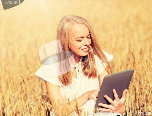 Image of happy young woman with tablet pc on cereal field