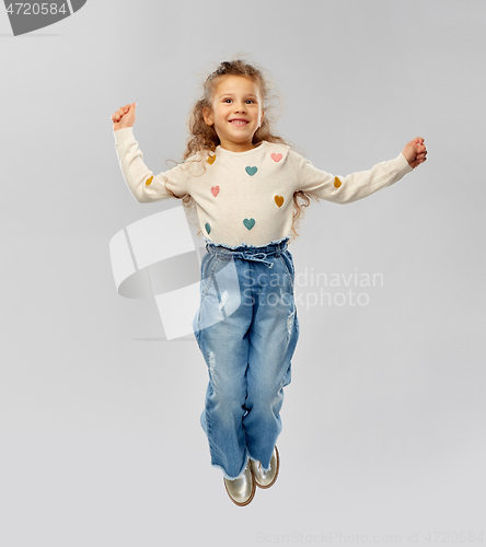 Image of smiling little girl jumping