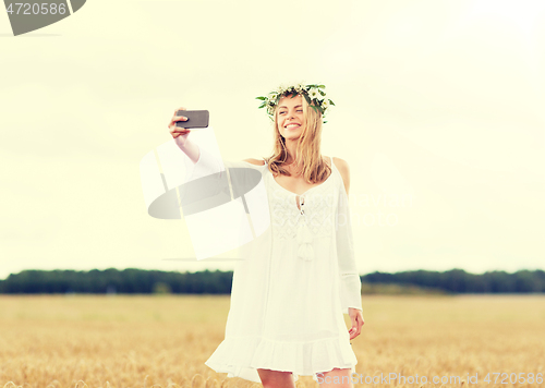 Image of happy young woman taking selfie by smartphone