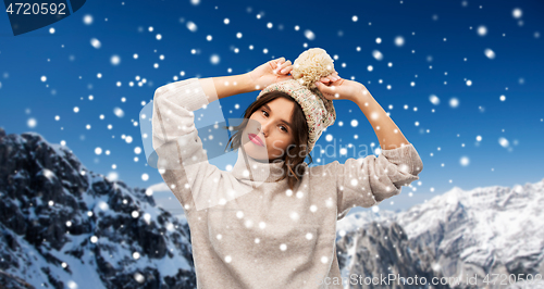 Image of young woman in knitted winter hat and sweater