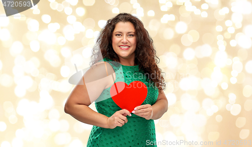 Image of happy woman holding red heart over lights