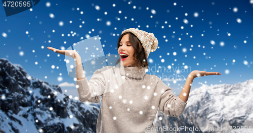 Image of young woman in winter hat holding something