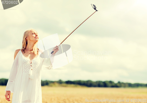 Image of happy young woman taking selfie by smartphone