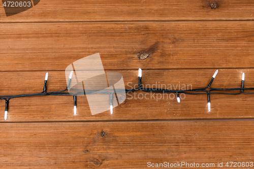 Image of christmas garland lights on wooden background