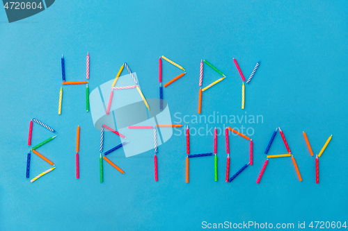 Image of words happy birthday made of candles on blue