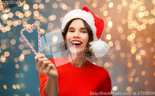 Image of happy young woman in santa hat on christmas