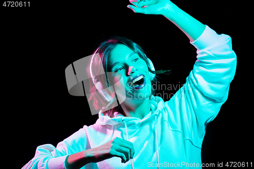 Image of woman in headphones listening to music and dancing