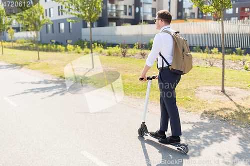 Image of businessman with backpack riding electric scooter