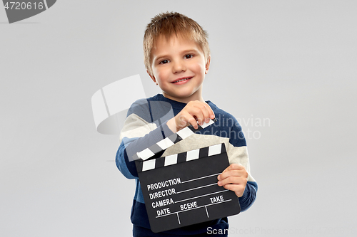 Image of happy little boy with clapperboard in studio