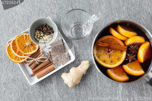 Image of pot with hot mulled wine, orange slices and spices