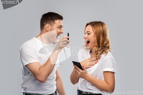 Image of happy couple in white t-shirts with smartphones