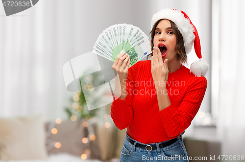 Image of woman in santa hat with money on christmas