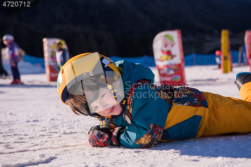 Image of little snowboarder lying on the snow