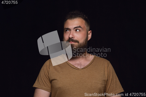 Image of Close up portrait of young man isolated on black studio background