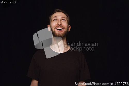 Image of Close up portrait of young man isolated on black studio background