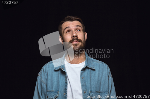 Image of Close up portrait of young man isolated on black studio background