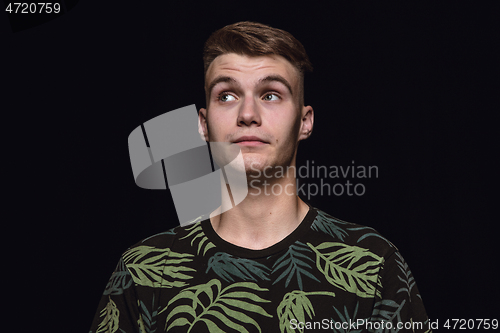 Image of Close up portrait of young man isolated on black studio background