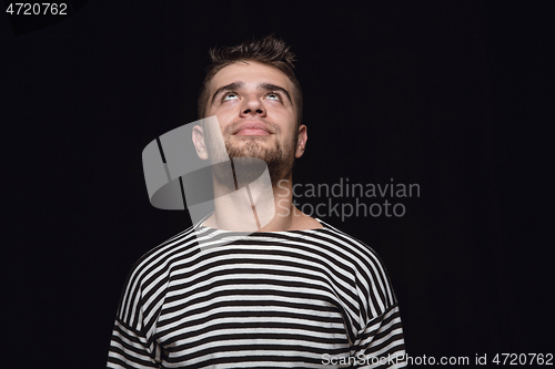 Image of Close up portrait of young man isolated on black studio background