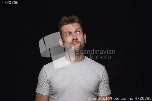 Image of Close up portrait of young man isolated on black studio background