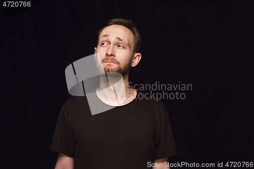 Image of Close up portrait of young man isolated on black studio background