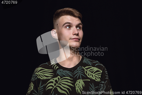 Image of Close up portrait of young man isolated on black studio background