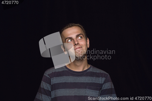 Image of Close up portrait of young man isolated on black studio background