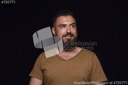 Image of Close up portrait of young man isolated on black studio background