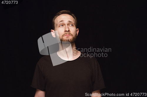 Image of Close up portrait of young man isolated on black studio background