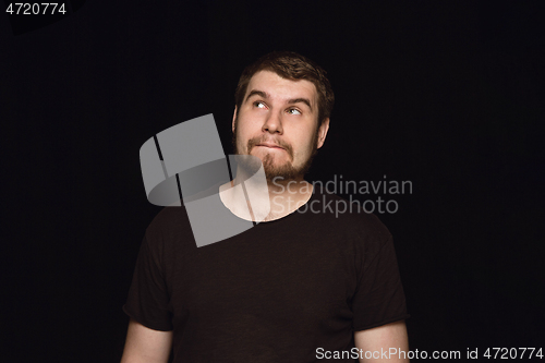 Image of Close up portrait of young man isolated on black studio background