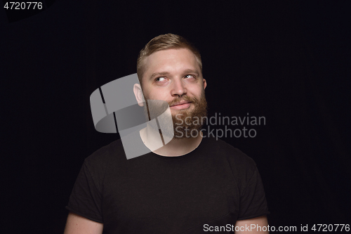 Image of Close up portrait of young man isolated on black studio background