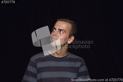 Image of Close up portrait of young man isolated on black studio background