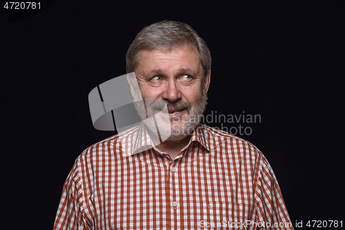 Image of Close up portrait of senior man isolated on black studio background