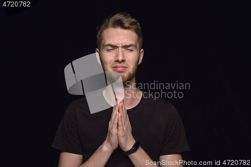 Image of Close up portrait of young man isolated on black studio background