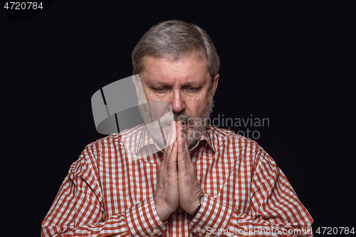 Image of Close up portrait of senior man isolated on black studio background