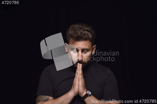 Image of Close up portrait of young man isolated on black studio background