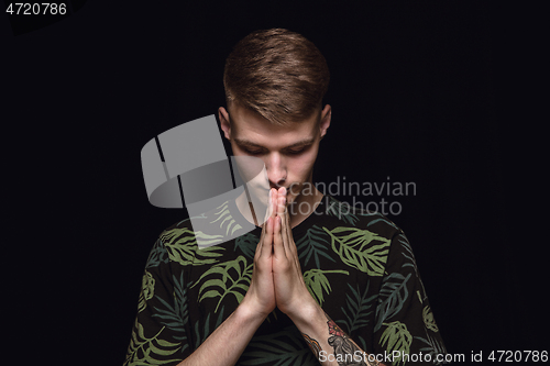 Image of Close up portrait of young man isolated on black studio background