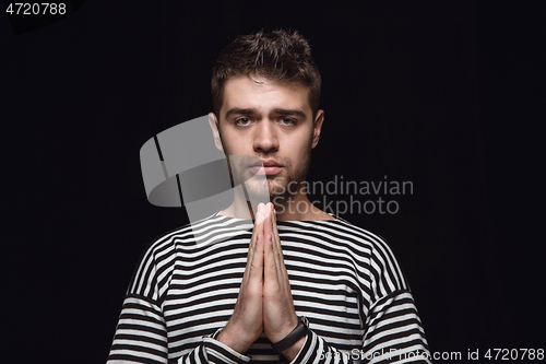 Image of Close up portrait of young man isolated on black studio background