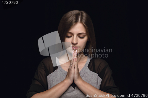 Image of Close up portrait of young woman isolated on black studio background