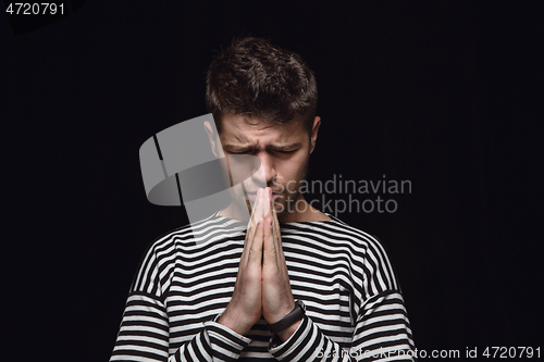 Image of Close up portrait of young man isolated on black studio background