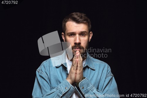 Image of Close up portrait of young man isolated on black studio background