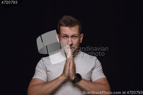 Image of Close up portrait of young man isolated on black studio background