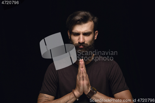 Image of Close up portrait of young man isolated on black studio background