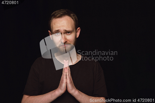 Image of Close up portrait of young man isolated on black studio background