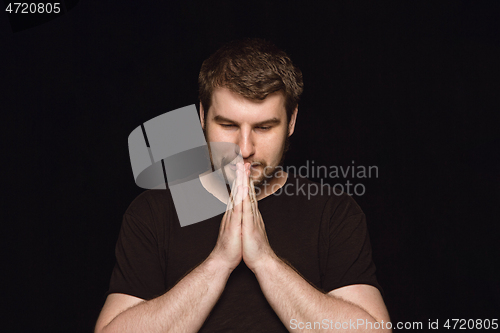 Image of Close up portrait of young man isolated on black studio background