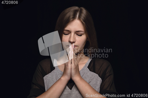 Image of Close up portrait of young woman isolated on black studio background