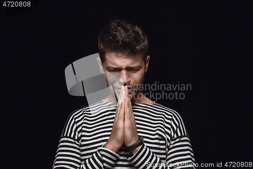 Image of Close up portrait of young man isolated on black studio background