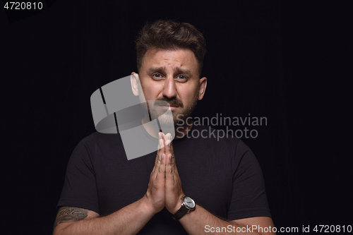 Image of Close up portrait of young man isolated on black studio background