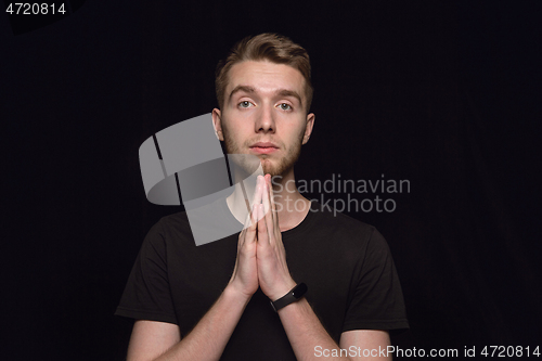 Image of Close up portrait of young man isolated on black studio background