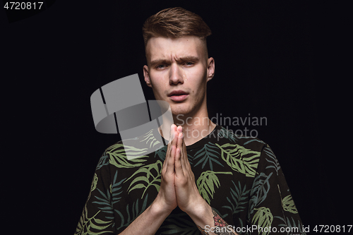 Image of Close up portrait of young man isolated on black studio background